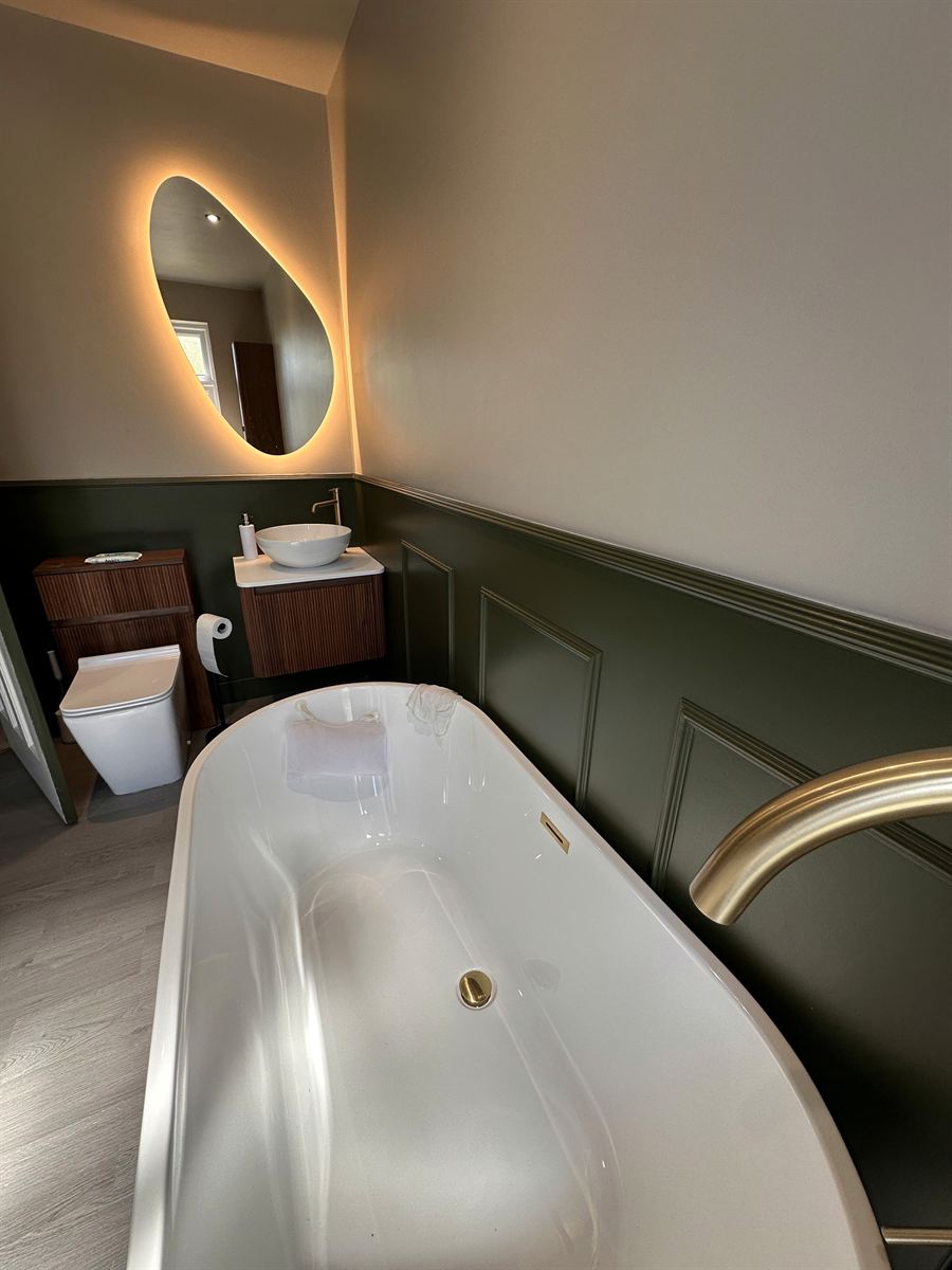Modern bathroom with freestanding bath and ambient mirror lighting